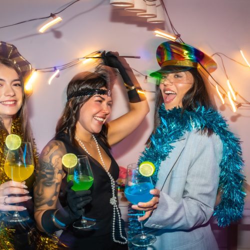 Friends celebrating a costume party at home with cocktails